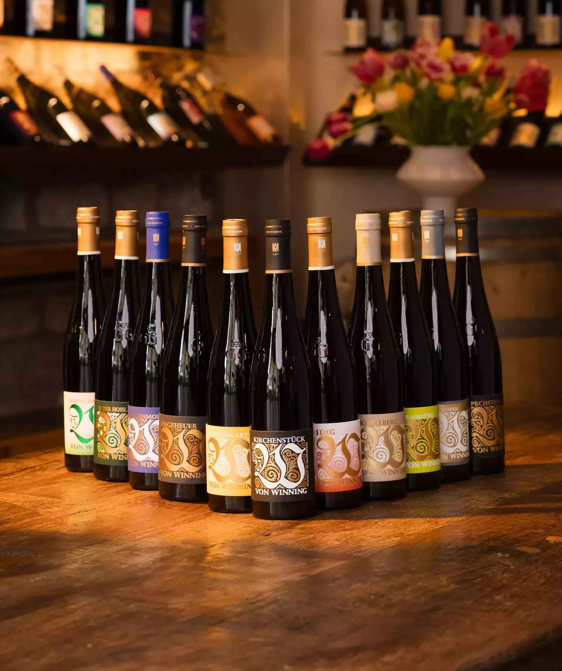Mehrere Weinflaschen stehen auf einem Holztisch.